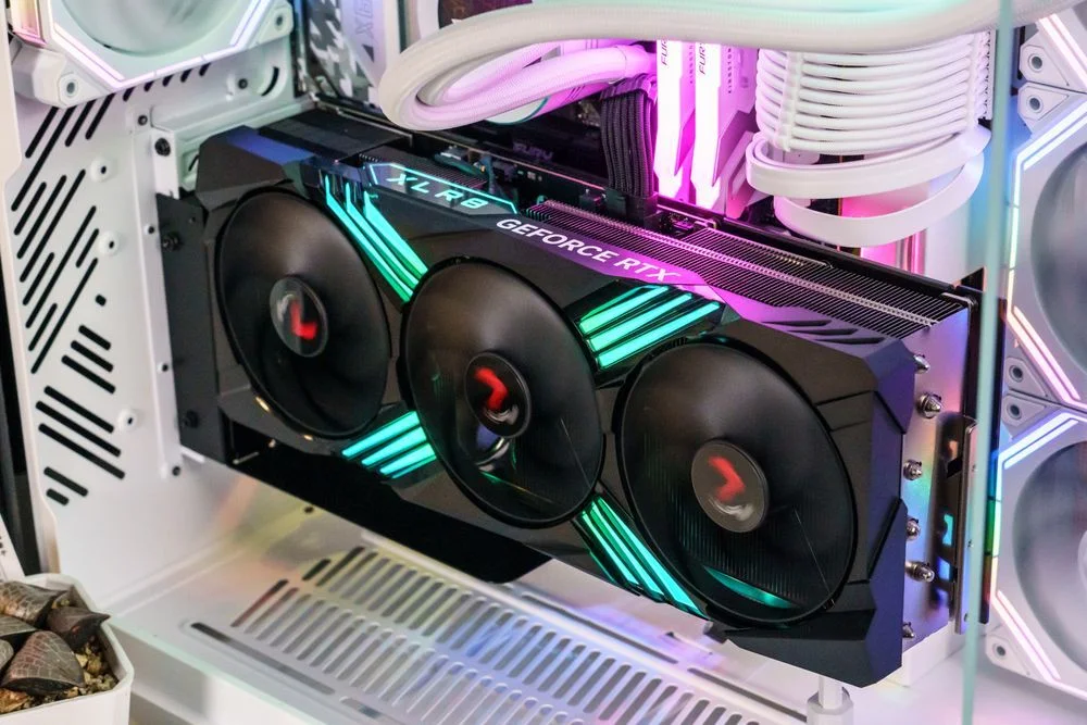A graphics card mounted vertically in a PC case using a dedicated bracket and a 90° PCIe riser